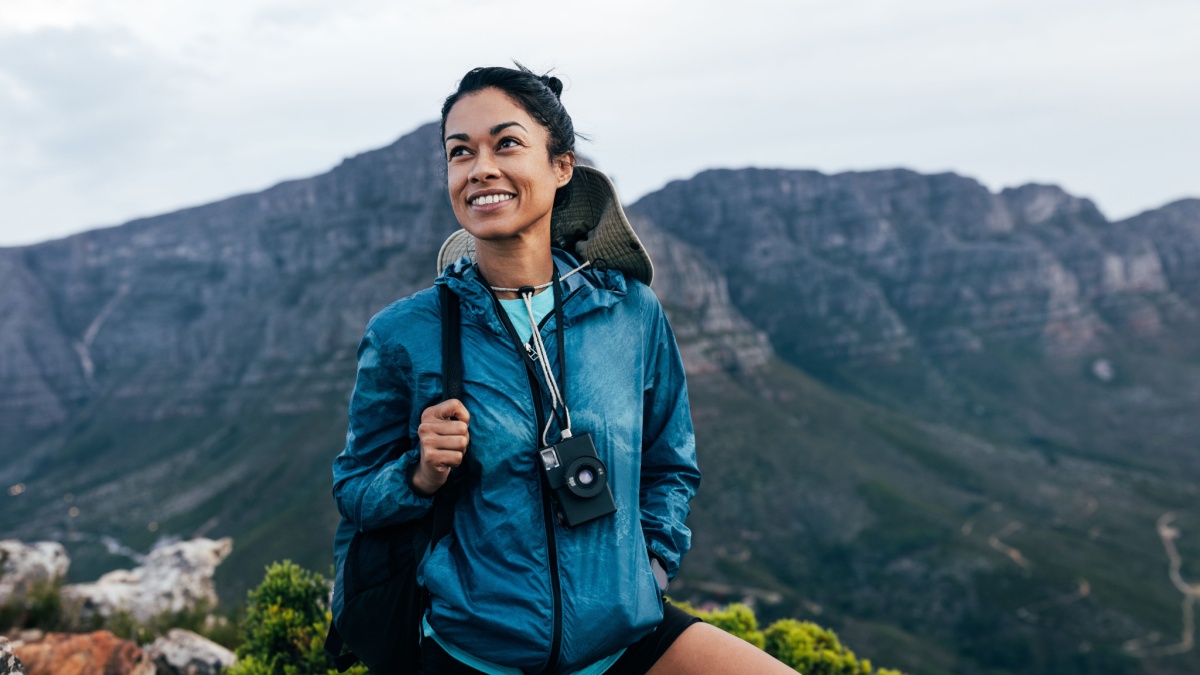 Portrait of a smiling woman relaxing during a mountain hike.