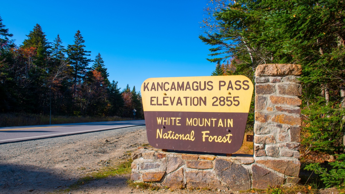 Sign of Kancamagus Pass on the highest point on Kancamagus Highway in White Mountain National Forest in fall, Town of Lincoln, New Hampshire NH, USA.