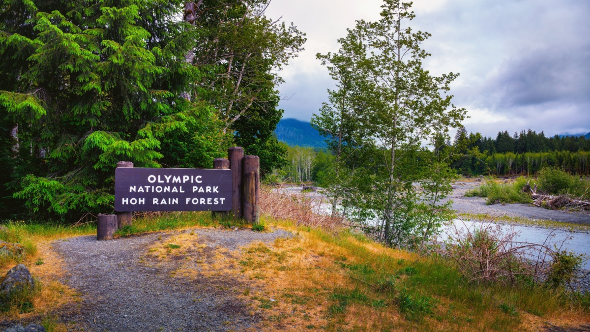 Welcome sign at the entrance to Olympic National Park Hoh Rain Forest by Hoh River with trees in Washington State, USA.