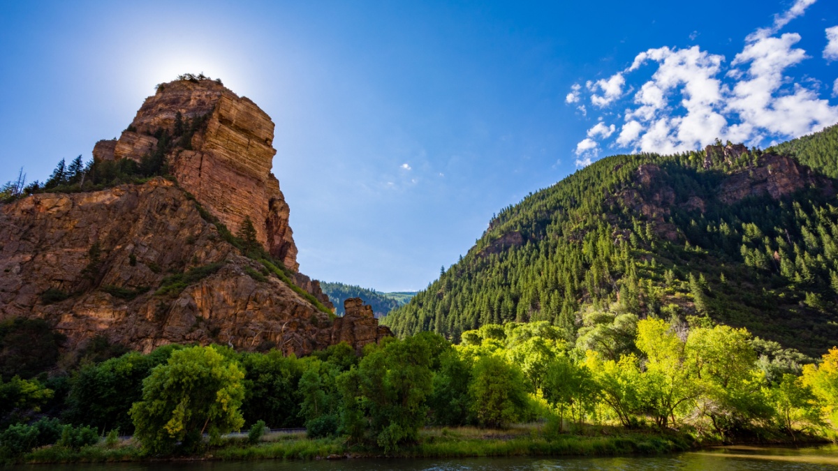 View of a rock formation and forested hill at the beginning of the trail to Hanging Lake near Glenwood Springs, Colorado.