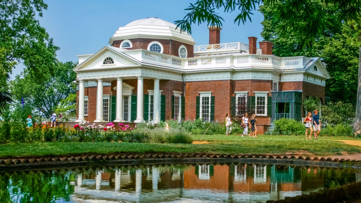Monticello, Virginia/USA - 05/25/2007; View of Thomas Jefferson's estate Monticello in summer; visitors walking in front of the building; building reflects in pond in front of it.