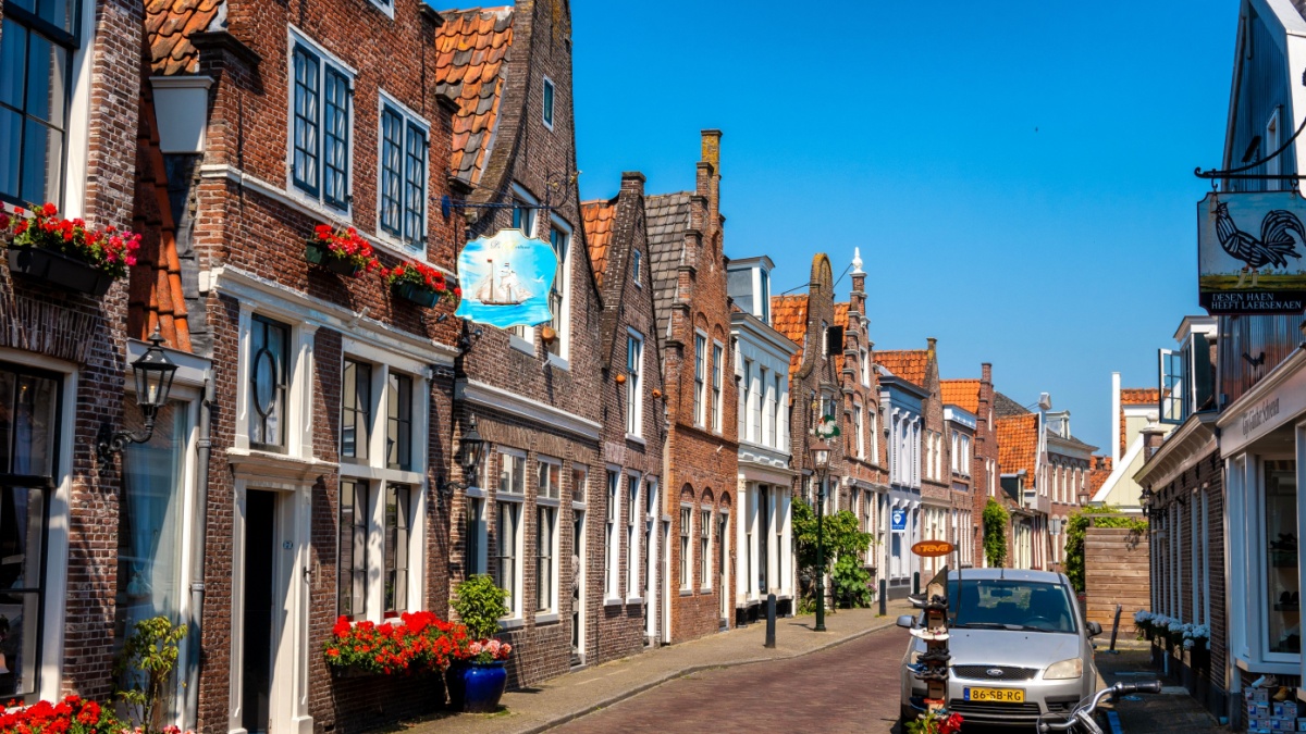 Edam, Netherlands, May 28th, 2023: Beautiful houses in rows, connected to each other, made from dutch red brick, with playful front facades in the streets of Edam, Netherlands.