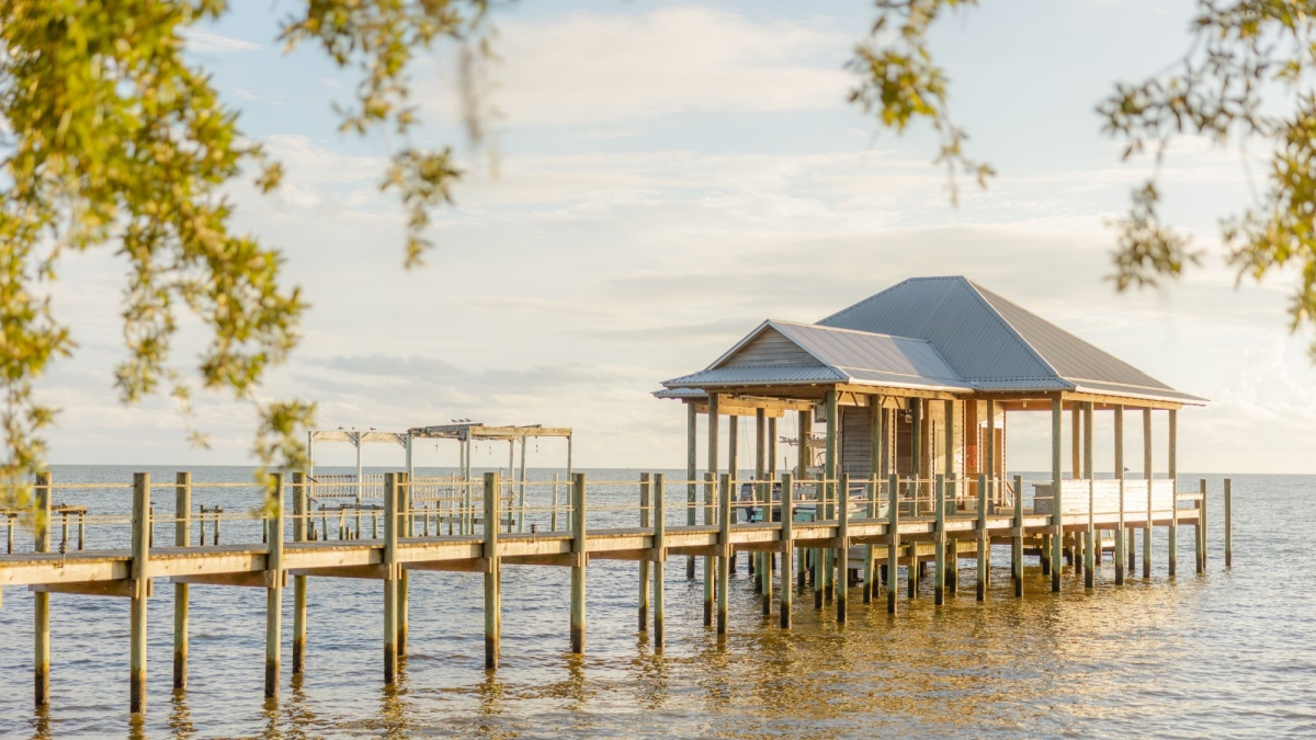 A scenic view of a picturesque lake with a peaceful pier and lush in Fairhope, Alabama.