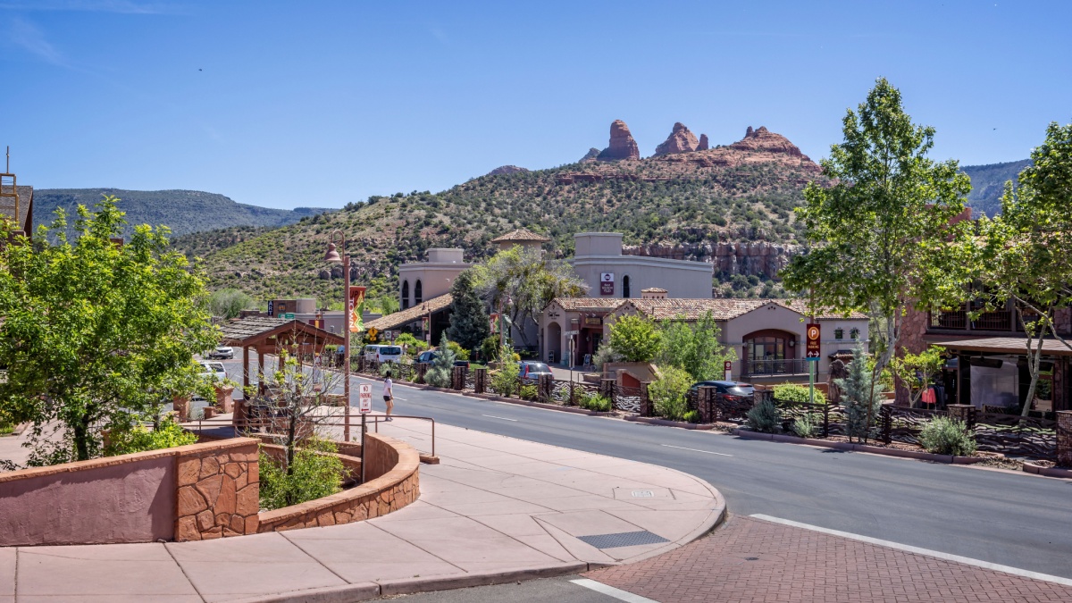 Uptown Sedona shops with red rock buttes in background in Sedona, Arizona, USA on 1 May 2024.
