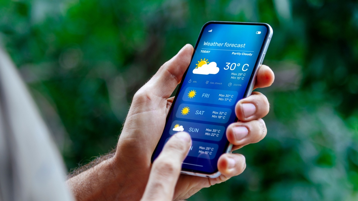 Man outdoors checking weather forecast on his mobile phone.