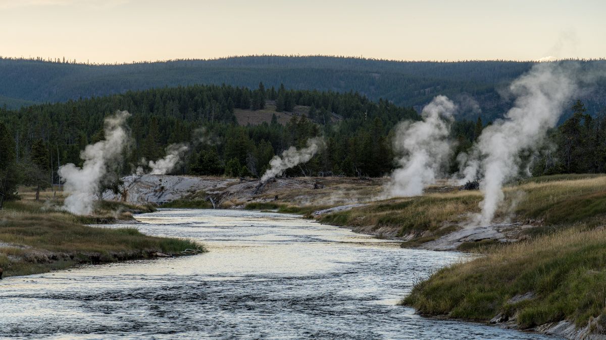 Steaming shores of Firehole River in the Upper Geyser Basin of Yellowstone National Park at the dusk.