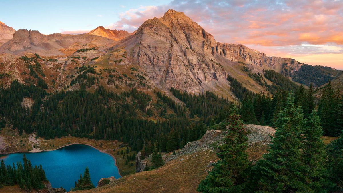 A brilliant sunrise at the lower Blue Lake in Mount Sneffels Wilderness, Ridgeway, Colorado during the falls season. A backpacking adventure.