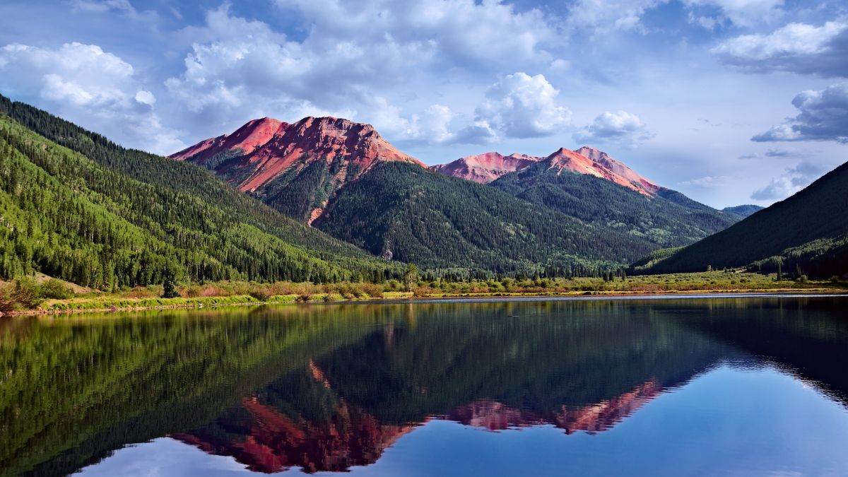 Colorado Mountains San Juan Skyway, Adventure On Red Iron Peaks Reflecting In A Crystal Clear High Mountain Trout Lake, Backpack & Fishing Country With Conifer Pines and Aspens, USA.
