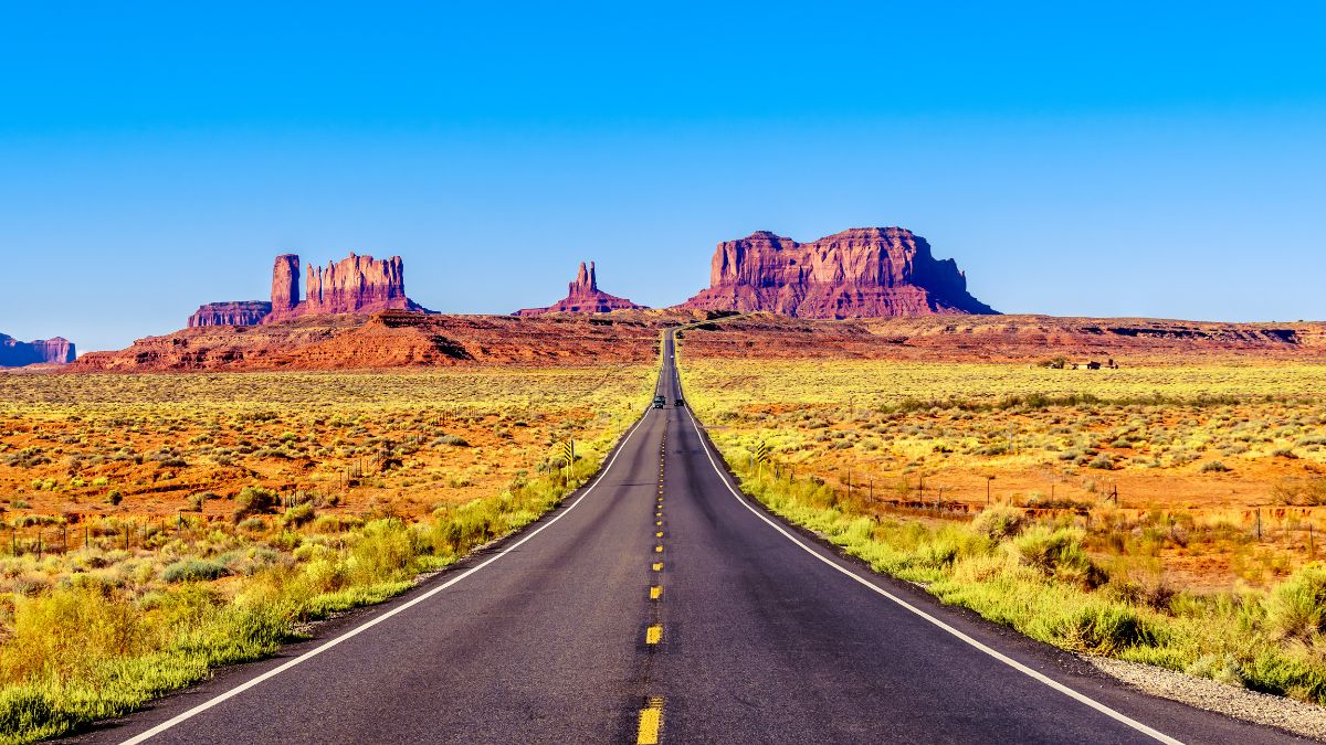 Highway 163 leading to the towering sandstone Buttes and Mesas of the Monument Valley Navajo Tribal Park in Utah-Arizona, United States. 'Forest Gump Point' where he stopped his cross country run.
