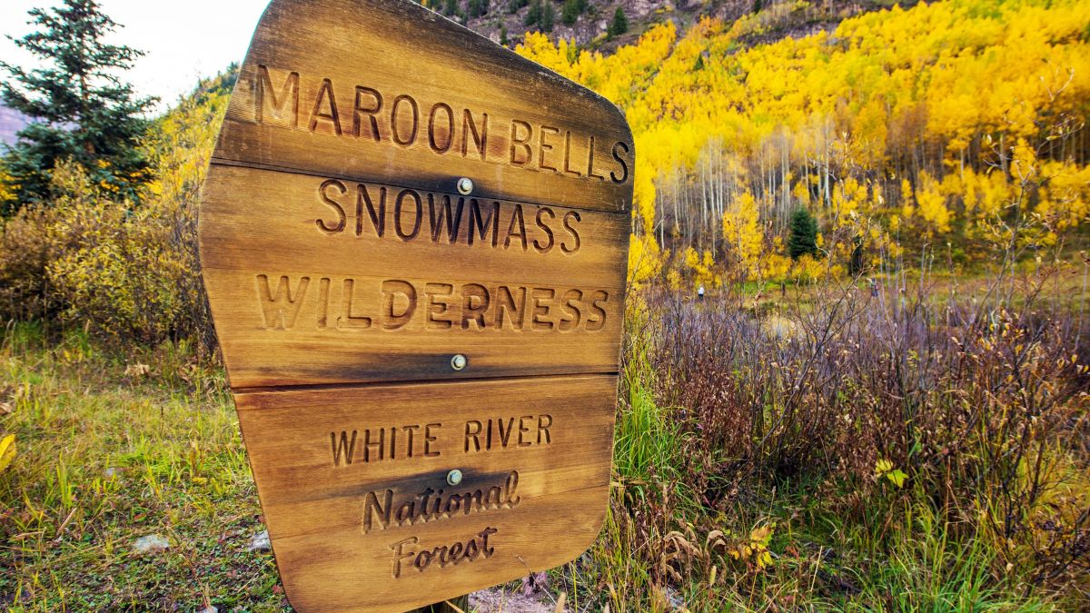 Maroon Bells Snowmass Wilderness - White River National Forest Wooden Sign near Maroon Bells, Aspen, Colorado, United States.