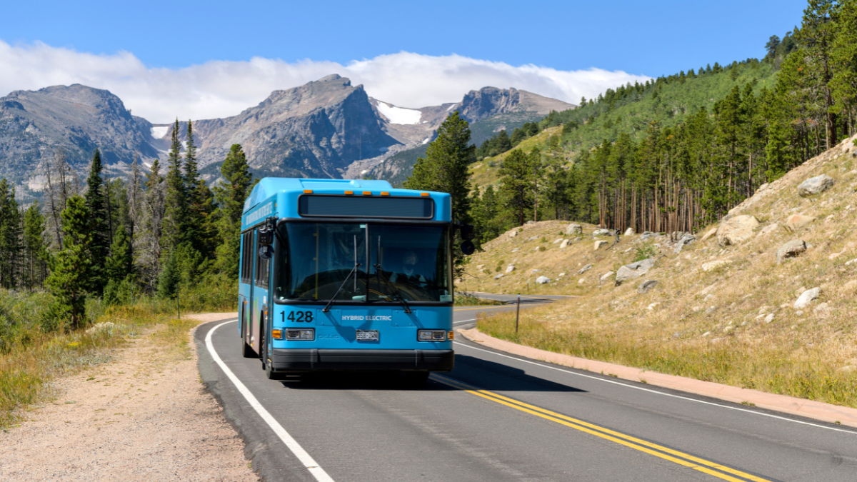 Estes Park, Colorado, USA - September 1, 2020:  A hybrid electric shuttle bus running on scenic Bear Lake Road on a sunny Summer morning in Rocky Mountain National Park.
