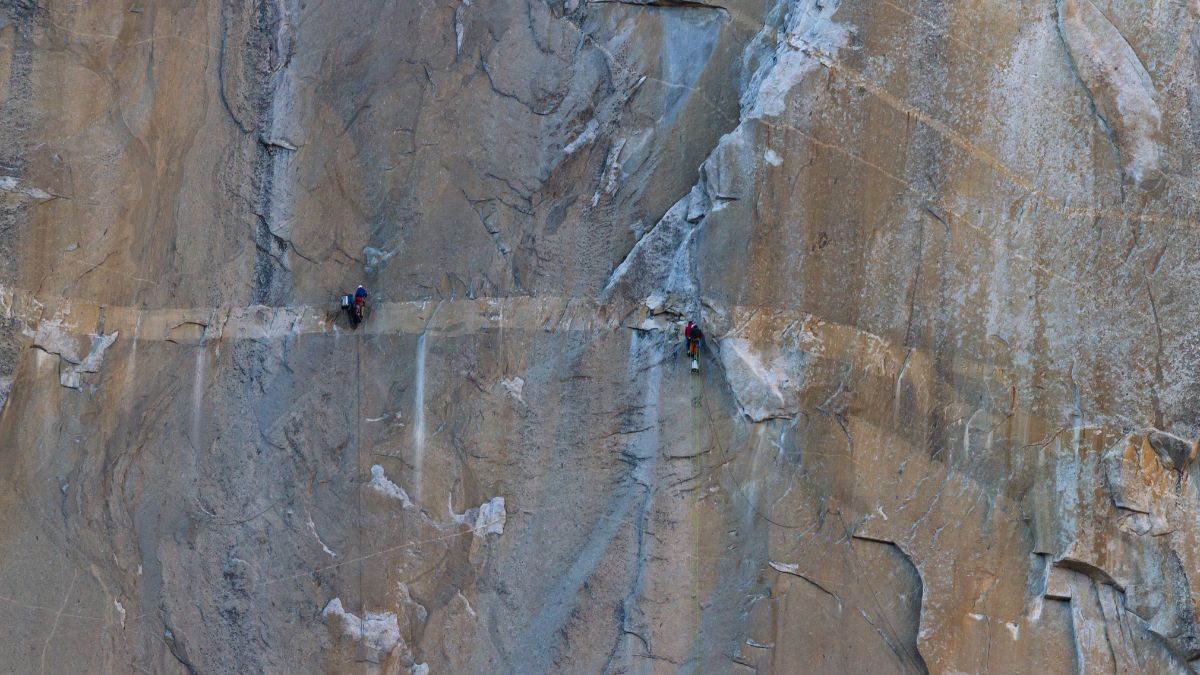 two sets of climbers climbing the giant granite rock wall of El Capitan in Yosemite NP.